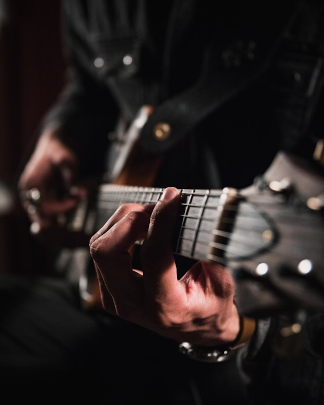 Dettaglio di una mano che suona la chitarra